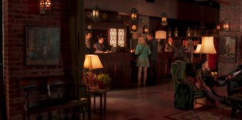 Movie still from “A Rainy Day in New York” (2019), directed by Woody Allen – A group of people standing in a room; Wide shot, Over the shoulder angle