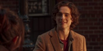 Movie still from “A Rainy Day in New York” (2019), directed by Woody Allen – A man with long brown hair wearing a brown jacket; Close Up shot, Over the shoulder angle
