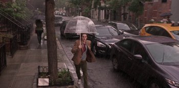 Movie still from “A Rainy Day in New York” (2019), directed by Woody Allen – A man walking down the street holding an umbrella; Wide shot, High angle