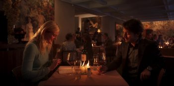 Movie still from “A Rainy Day in New York” (2019), directed by Woody Allen – A man and a woman sitting at a dinner table; Medium shot, High angle