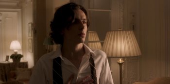 Movie still from “A Rainy Day in New York” (2019), directed by Woody Allen – A young man in a white shirt and a black neck tie; Medium shot, Low angle