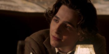 Movie still from “A Rainy Day in New York” (2019), directed by Woody Allen – A person wearing a suit and tie; Close Up shot, Over the shoulder angle