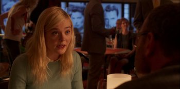 Movie still from “A Rainy Day in New York” (2019), directed by Woody Allen – A woman sitting at a table with a glass of wine; Medium shot, Over the shoulder angle