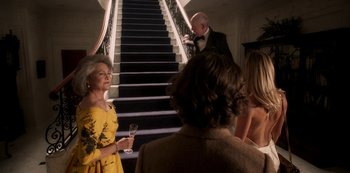 Movie still from “A Rainy Day in New York” (2019), directed by Woody Allen – A group of people standing in front of a staircase; Medium shot, Low angle