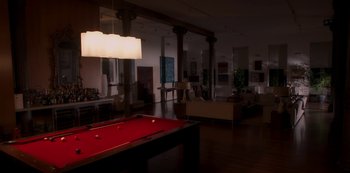 Movie still from “A Rainy Day in New York” (2019), directed by Woody Allen – A room with a pool table and a couch; Extreme Wide shot, High angle