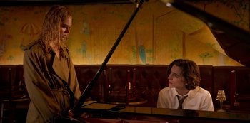 Movie still from “A Rainy Day in New York” (2019), directed by Woody Allen – Two young people are sitting at a piano in a restaurant; Medium shot, Over the shoulder angle