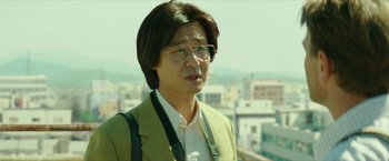An asian man wearing glasses and a jacket