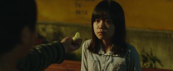 A person holding an apple in front of a woman