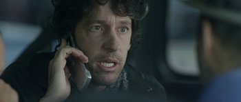 Movie still from “A Thousand Junkies” (2017), directed by Tommy Swerdlow – A person talking on a cell phone; Close Up shot, Low angle