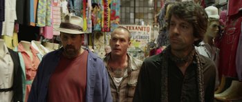 Movie still from “A Thousand Junkies” (2017), directed by Tommy Swerdlow – A group of men standing next to each other in a store; Medium shot, Over the shoulder angle