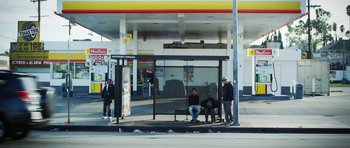 Movie still from “A Thousand Junkies” (2017), directed by Tommy Swerdlow – A group of people waiting at a bus stop; Wide shot, Low angle