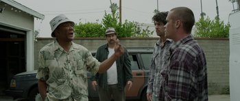 Movie still from “A Thousand Junkies” (2017), directed by Tommy Swerdlow – A group of men standing next to each other near a car; Medium shot, Over the shoulder angle