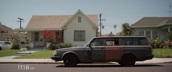 Movie still from “A Thousand Junkies” (2017), directed by Tommy Swerdlow – An old car parked on the side of the street; Wide shot, Low angle