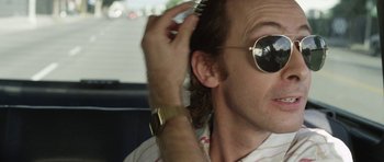 Movie still from “A Thousand Junkies” (2017), directed by Tommy Swerdlow – A person with sunglasses on; Close Up shot, Over the shoulder angle