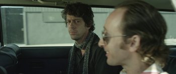 Movie still from “A Thousand Junkies” (2017), directed by Tommy Swerdlow – A man sitting in the back seat of a car; Close Up shot, Over the shoulder angle