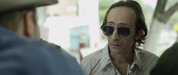 Movie still from “A Thousand Junkies” (2017), directed by Tommy Swerdlow – A person wearing sunglasses; Close Up shot, Over the shoulder angle