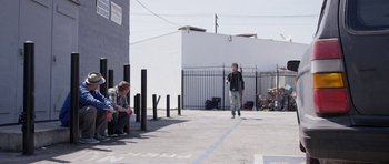 Movie still from “A Thousand Junkies” (2017), directed by Tommy Swerdlow – A man sitting on the ground next to another man; Wide shot, Over the shoulder angle