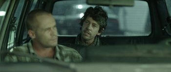 Movie still from “A Thousand Junkies” (2017), directed by Tommy Swerdlow – A man sitting in the back seat of a car; Medium shot, Over the shoulder angle