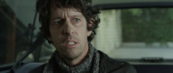 Movie still from “A Thousand Junkies” (2017), directed by Tommy Swerdlow – A person wearing a scarf; Close Up shot, Over the shoulder angle