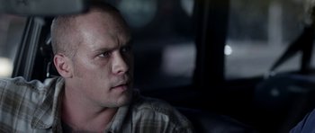 Movie still from “A Thousand Junkies” (2017), directed by Tommy Swerdlow – A person sitting in a car; Close Up shot, Over the shoulder angle