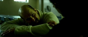 Movie still from “A Thousand Junkies” (2017), directed by Tommy Swerdlow – A man in a green sweater looking at another man in a green shirt; Close Up shot, Over the shoulder angle