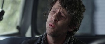 Movie still from “A Thousand Junkies” (2017), directed by Tommy Swerdlow – A person wearing a black jacket; Close Up shot, Over the shoulder angle