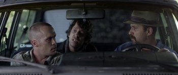 Movie still from “A Thousand Junkies” (2017), directed by Tommy Swerdlow – A group of men sitting in the back seat of a car; Medium shot, Over the shoulder angle