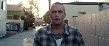 Movie still from “A Thousand Junkies” (2017), directed by Tommy Swerdlow – A man in a plaid shirt with a tattoo on his chest; Close Up shot, Low angle