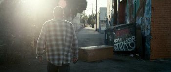 Movie still from “A Thousand Junkies” (2017), directed by Tommy Swerdlow – A man walking down a street holding a hand; Wide shot, Low angle