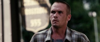 Movie still from “A Thousand Junkies” (2017), directed by Tommy Swerdlow – A person wearing a plaid shirt; Close Up shot, Over the shoulder angle