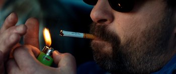 Movie still from “A Thousand Junkies” (2017), directed by Tommy Swerdlow – A person lighting a cigarette; Extreme Close Up shot, Overhead angle