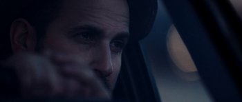 Movie still from “A Thousand Junkies” (2017), directed by Tommy Swerdlow – A man's face as he drives a car at night; Close Up shot, Over the shoulder angle