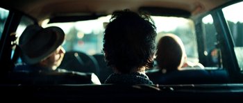 Movie still from “A Thousand Junkies” (2017), directed by Tommy Swerdlow – A person sitting in the back of a car; Close Up shot, Over the shoulder angle