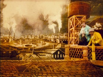 Movie still from “A Trip to the Moon” (1902), directed by Georges Méliès – An oil painting of an industrial scene with a man sitting on top of a water tower; Extreme Wide shot, Low angle