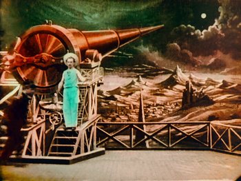 Movie still from “A Trip to the Moon” (1902), directed by Georges Méliès – A painting of a woman standing in front of a giant telescope; Wide shot, Low angle