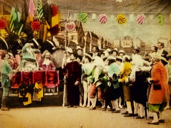 Movie still from “A Trip to the Moon” (1902), directed by Georges Méliès – A group of people standing around a parade float; Wide shot, Low angle