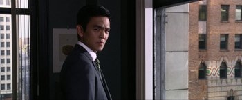 Movie still from “A Very Harold & Kumar Christmas” (2011), directed by Todd Strauss-Schulson – A man wearing a suit and tie standing in front of a window; Close Up shot, Over the shoulder angle