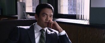 Movie still from “A Very Harold & Kumar Christmas” (2011), directed by Todd Strauss-Schulson – A man in a suit and tie sitting in front of a window; Close Up shot, Over the shoulder angle