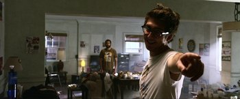 Two men in a living room , one of whom is wearing glasses
