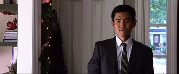 Movie still from “A Very Harold & Kumar Christmas” (2011), directed by Todd Strauss-Schulson – A man in a suit and tie standing in front of a door; Close Up shot, Over the shoulder angle