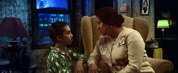 Movie still from “A Very Harold & Kumar Christmas” (2011), directed by Todd Strauss-Schulson – A woman sitting next to a young boy in a chair; Medium shot, Over the shoulder angle