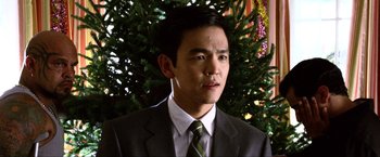 Movie still from “A Very Harold & Kumar Christmas” (2011), directed by Todd Strauss-Schulson – A man wearing a suit and tie in front of a christmas tree; Close Up shot, Over the shoulder angle