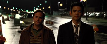 Movie still from “A Very Harold & Kumar Christmas” (2011), directed by Todd Strauss-Schulson – A couple of men standing next to each other on a street; Medium shot, Over the shoulder angle