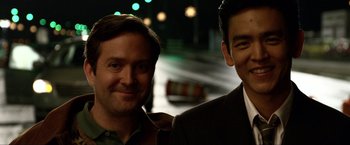 Movie still from “A Very Harold & Kumar Christmas” (2011), directed by Todd Strauss-Schulson – A couple of men standing next to each other on a street; Close Up shot, Over the shoulder angle