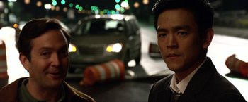 Movie still from “A Very Harold & Kumar Christmas” (2011), directed by Todd Strauss-Schulson – A man standing next to a car on a street; Close Up shot, Over the shoulder angle