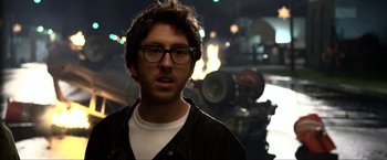 Movie still from “A Very Harold & Kumar Christmas” (2011), directed by Todd Strauss-Schulson – A man wearing glasses standing in a parking lot; Close Up shot, Over the shoulder angle