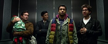 Movie still from “A Very Harold & Kumar Christmas” (2011), directed by Todd Strauss-Schulson – Two men standing next to each other in an elevator; Medium shot, Low angle