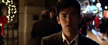 Movie still from “A Very Harold & Kumar Christmas” (2011), directed by Todd Strauss-Schulson – A man in a suit is looking at the camera; Close Up shot, Over the shoulder angle