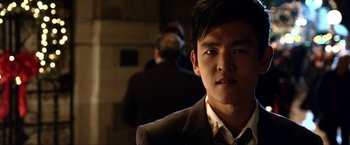 Movie still from “A Very Harold & Kumar Christmas” (2011), directed by Todd Strauss-Schulson – A man in a suit and tie looking at the camera; Close Up shot, Over the shoulder angle