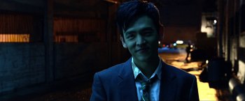Movie still from “A Very Harold & Kumar Christmas” (2011), directed by Todd Strauss-Schulson – A man wearing a suit and tie smiling for the camera; Close Up shot, Over the shoulder angle